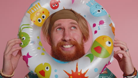 funny young hippie tourist man looking out of rubber swimming ring, summer vacation time, sea travel