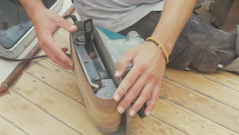 Changing-sandpaper-on-belt-sander.-Medium-close-up