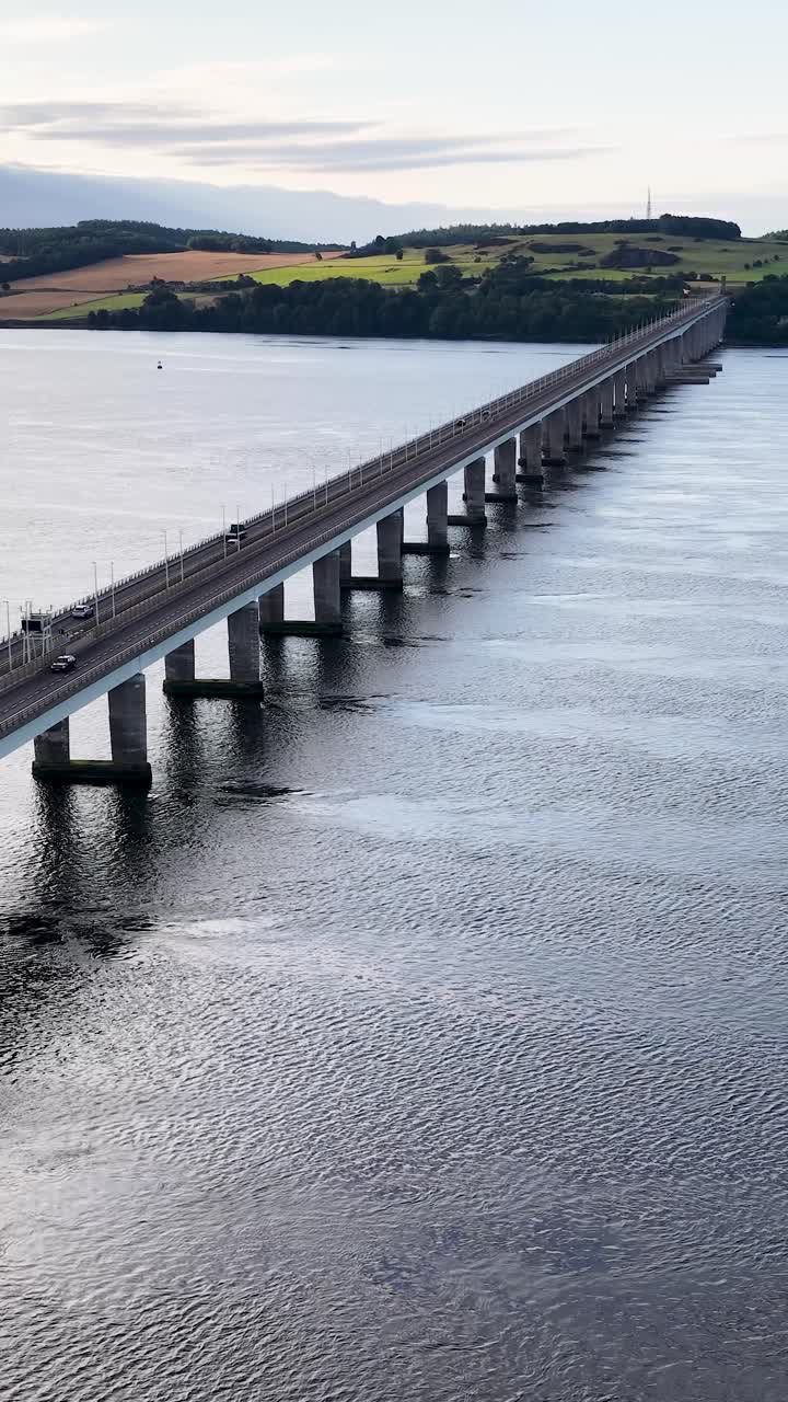 La telecamera del drone sorvola il Tay Road Bridge, rivelando il fiume, i veicoli e il paesaggio scozzese al tramonto.