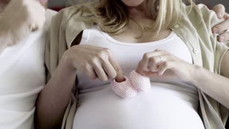 Cropped-shot-of-couple-holding-pink-babys-booties