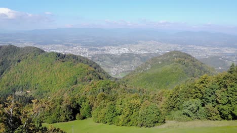 Panning-left-green-forest-mountain,-foliage-rustles-gently-in-breeze