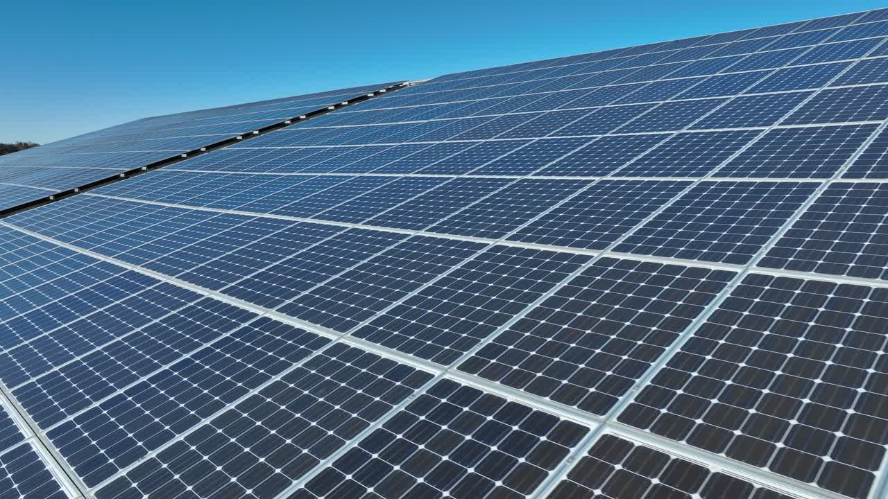 Pannelli fotovoltaici sul tetto di un edificio durante una giornata di sole e cielo blu.