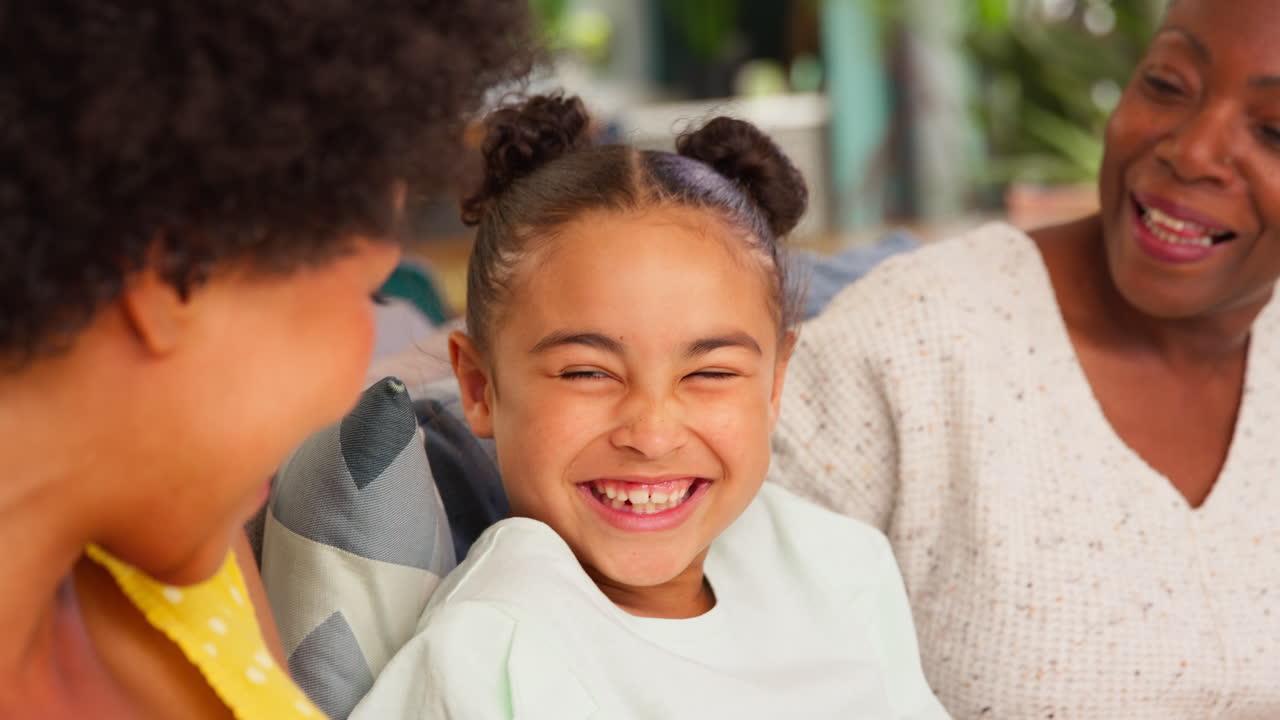 primer plano de una familia de mujeres de varias generaciones relajándose sentadas en el sofá en casa juntas