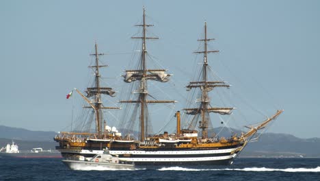 telephoto shot of italian amerigo vespucci tallship, military vehicle passing by