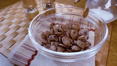 copos de chocolate crujientes en un tazón para un delicioso desayuno matutino con leche. cámara lenta con toma de seguimiento de rotación.