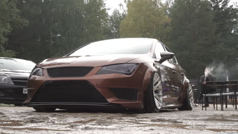 modified brown sedan at a car show