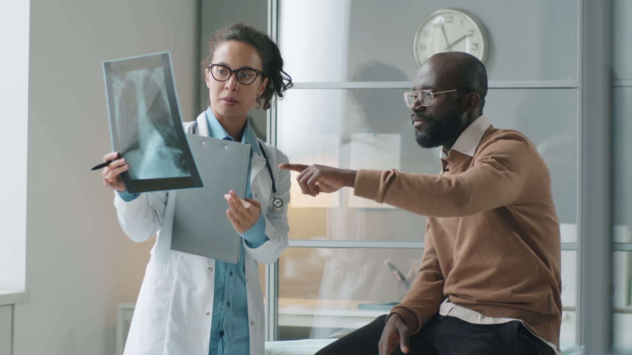 Female Doctor Explaining Chest X-Ray to African American Man in Clinic