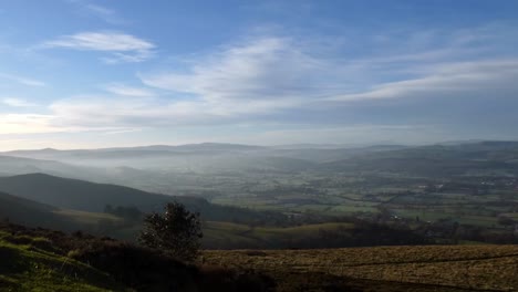 distant misty layers of panoramic rural moel famau mountain valley countryside at dreamlike sunrise