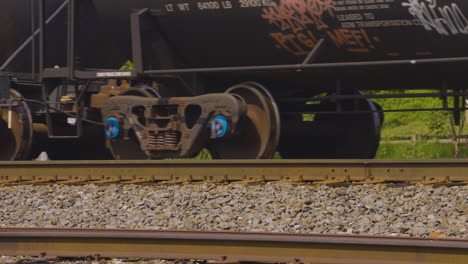 close shot of a trains wheels as the tanker cars roll by on the rusty train tracks in youngstown, ohio