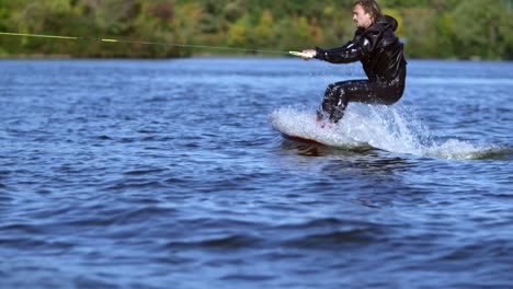 Man-start-wakeboarding-in-slow-motion.-Sportsman-riding-on-wakeboard