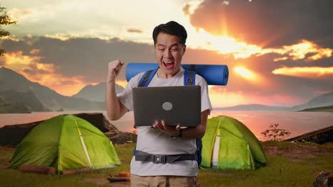 happy camper with laptop at sunrise