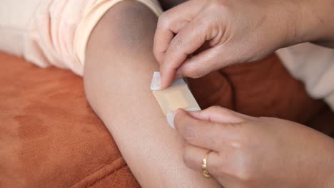 woman applying bandage to child's arm