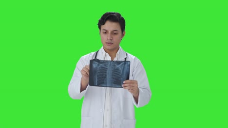 Serious-Indian-doctor-checking-X-ray-report-Green-screen