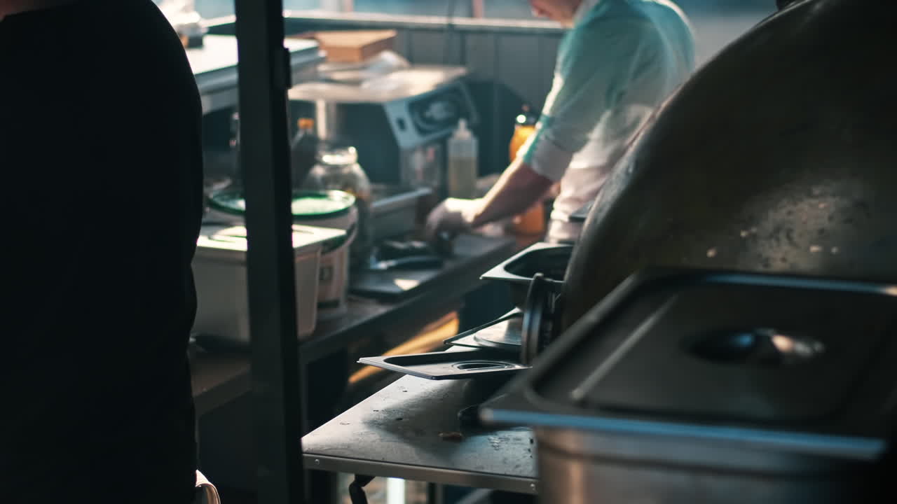 A cook is slicing a pickled cucumber in a restaurant. BBQ