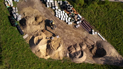 aerial top down shot of construction site with working excavator during sunny day in poland