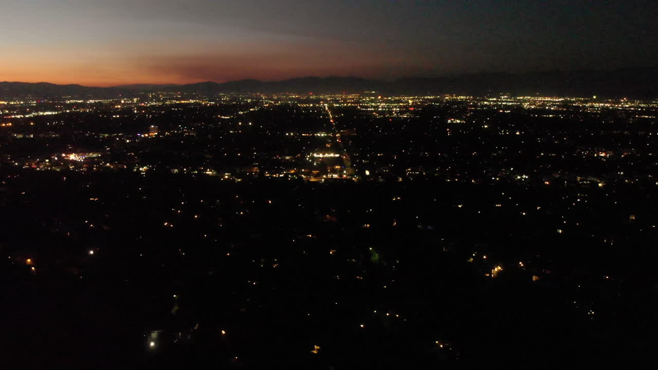분주한 계곡 도시 위로 폭발하는 수천 개의 휴일 불꽃놀이의 공중 저속 촬영