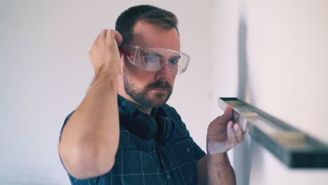 man in goggles stressed out of troubles with wall in room