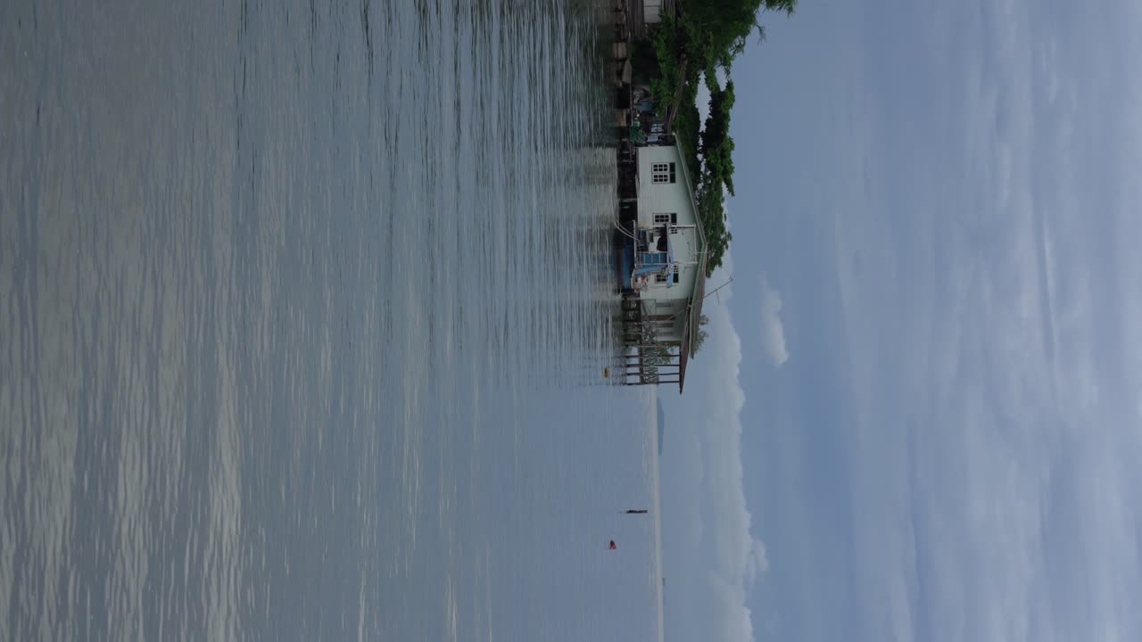 video vertical: la brisa tranquila fluye a través de casas sobre pilotes de pescadores construidas en el mar en tailandia