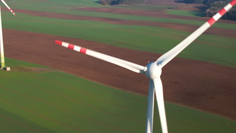 wind turbine generate electric power on sunset with agricultural field in background