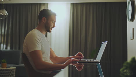 hombre trabajando desde casa en la computadora portátil