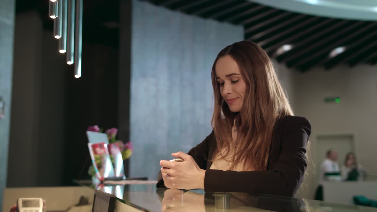 mujer de negocios que utiliza el teléfono móvil para el pago sin contacto en la recepción del hotel