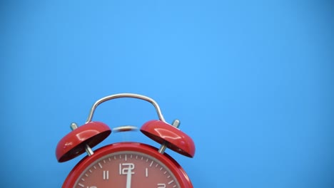 red alarm clock on blue background