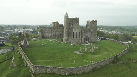 Medieval-Fortress-Of-The-Rock-Of-Cashel-On-Top-Of-The-Hill-In-County-Tipperary,-Ireland,-aerial,-dolly-zoom