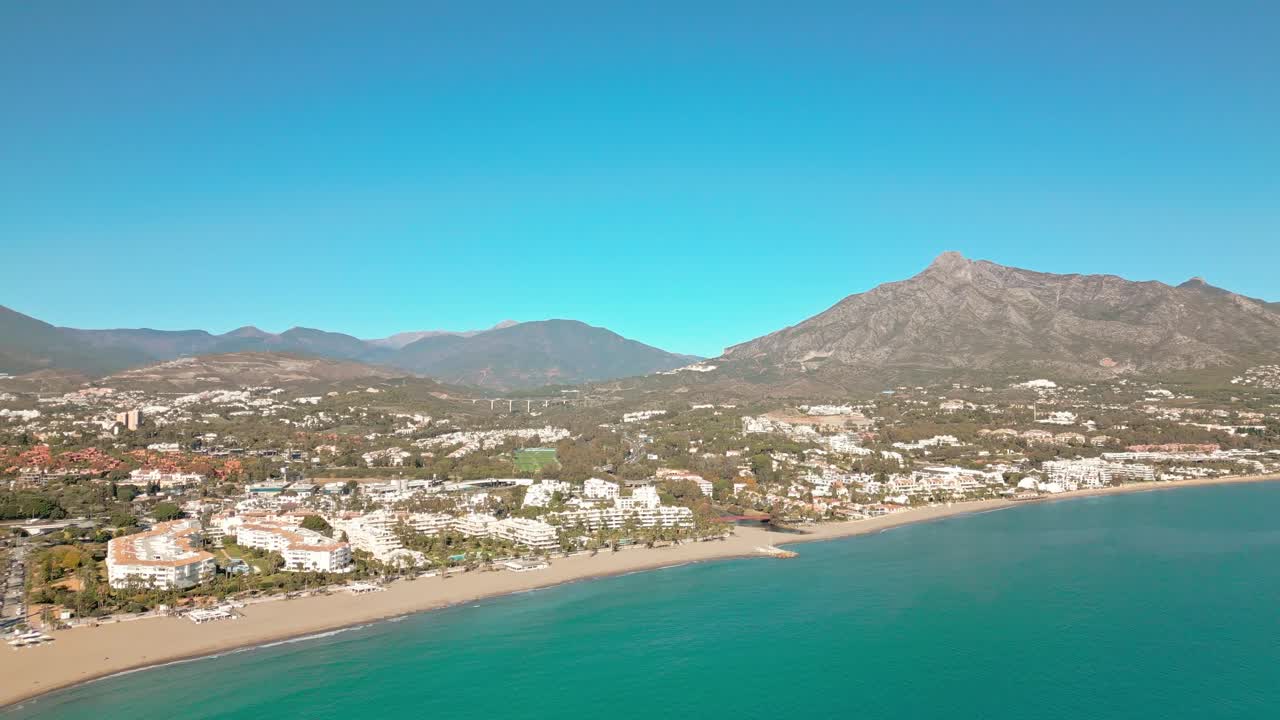 Vista aerea della spiaggia di Marbella con la montagna La Concha sullo sfondo, Costa del Sol, Spagna meridionale, sotto un cielo mediterraneo soleggiato