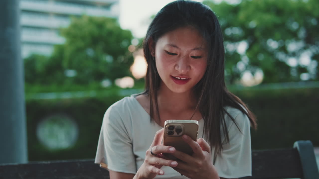 Asian woman using smartphone outdoors