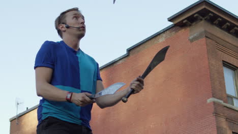 juggler finishes juggling swords in slow motion