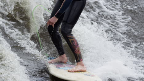 woman athlete - surfing on a river wave