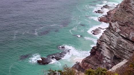 waves crashing over rocks with beautiful blue water