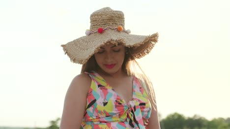 una chica embarazada camina con un hermoso vestido y sombrero