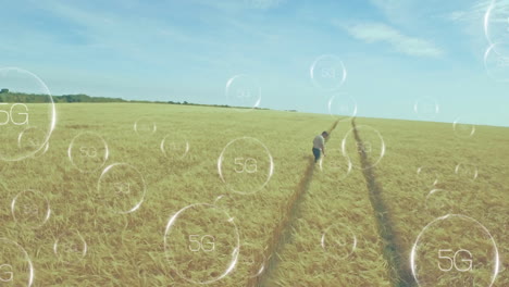 walking through wheat field, child with animation of 5g network symbols