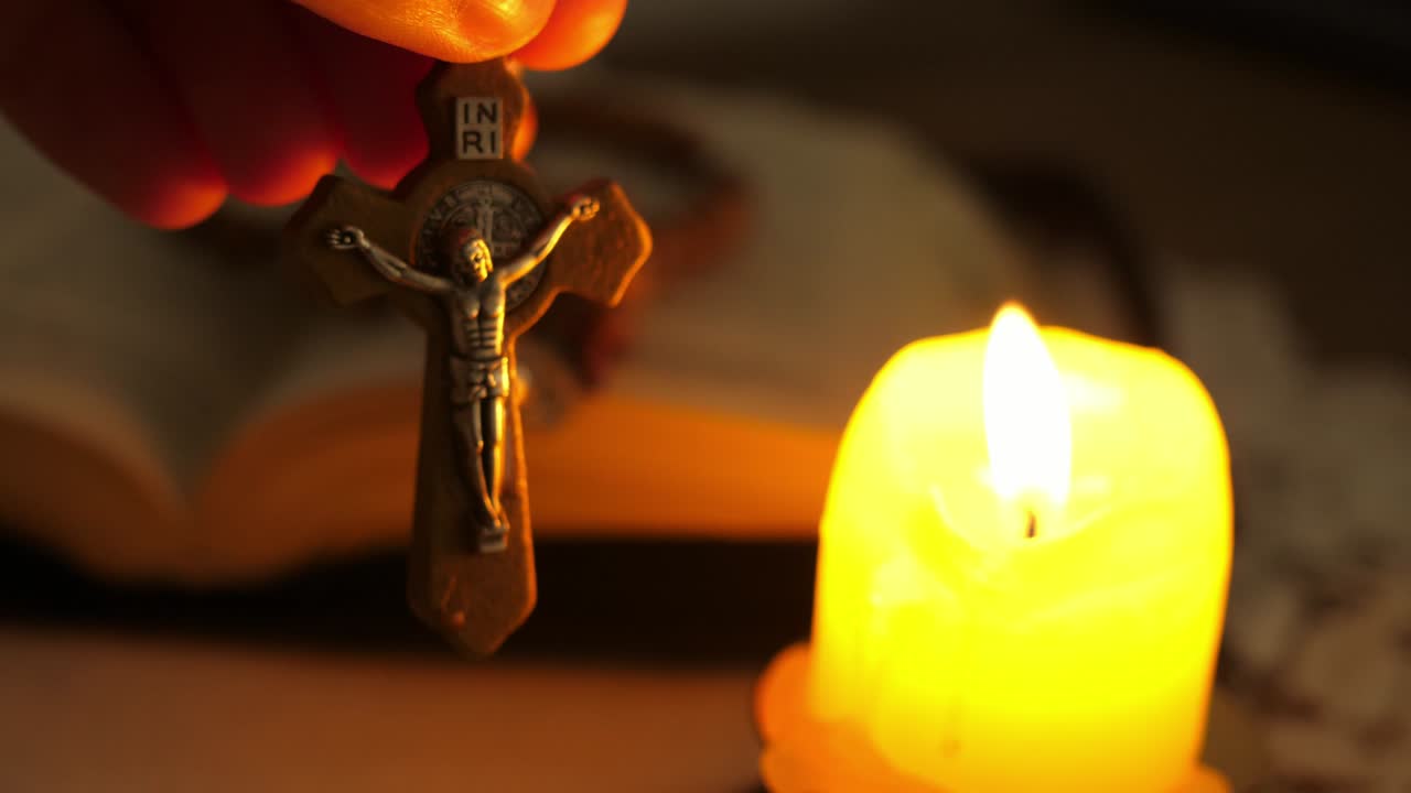 cruz con cristo jesús en el crepúsculo iluminado por la luz de la vela