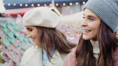 Video-Von-Zwei-Frauen,-Die-Spazieren-Gehen-Und-Weihnachtsmarktstände-Durchstöbern