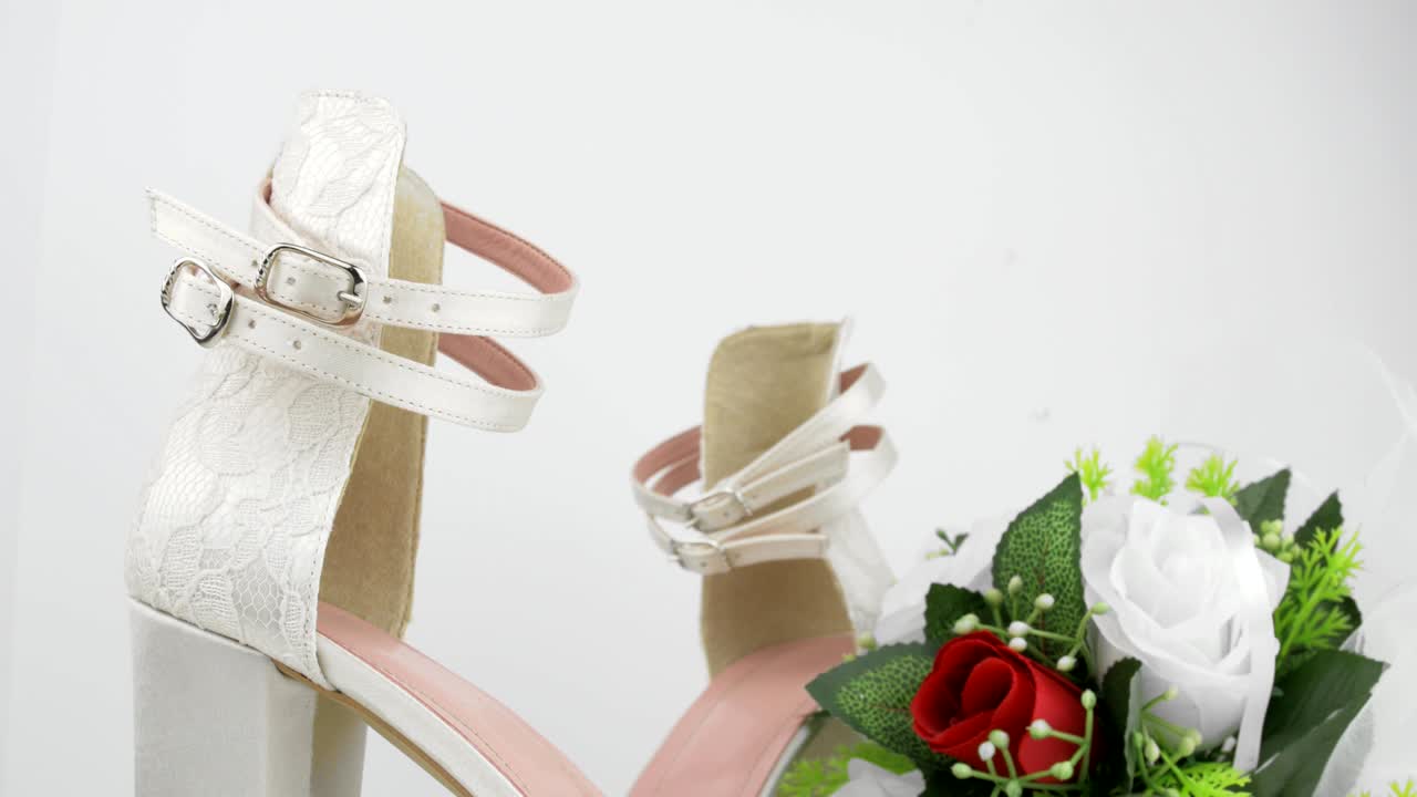 화이트 배경 클로즈업에 은 장미와 함께 우아한 럭셔리 라스 신부 결혼 신발과 꽃줄