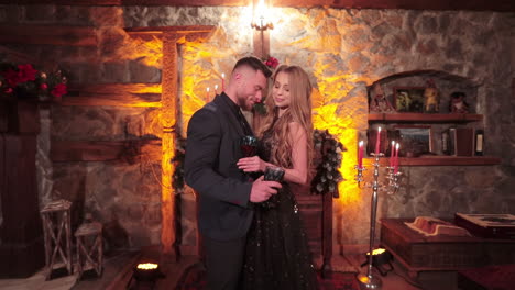 two happy people in beautiful clothes having date. couple in love celebrating holidays in rural stone house.
