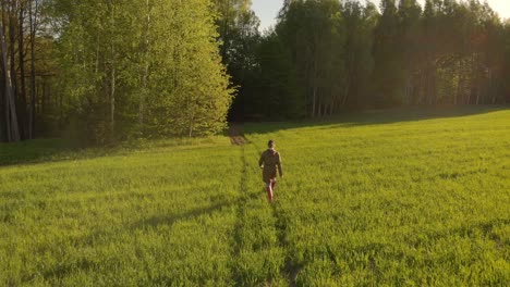 back view woman walking on spring countryside path in northern europe