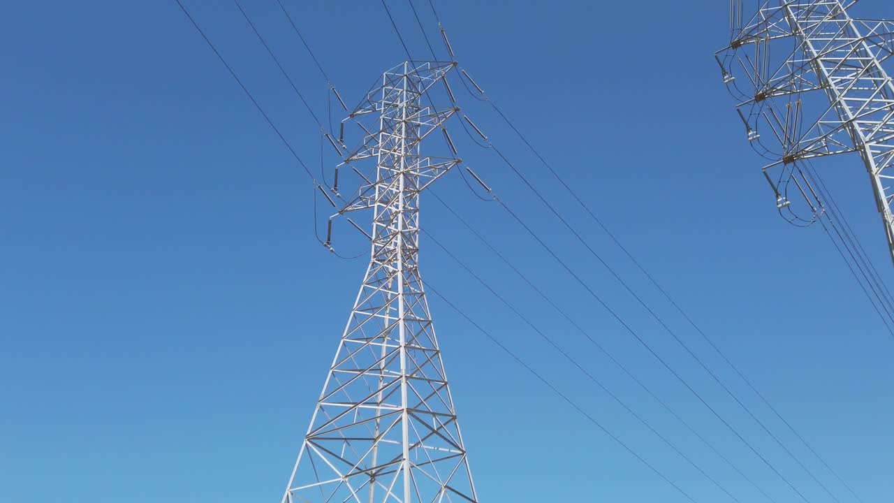 Højspændingsmast mod en blå himmel med elledninger