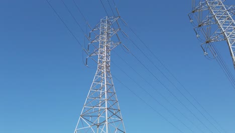 electricity transformer tower on a blue sky backdrop with electric cable wires lines