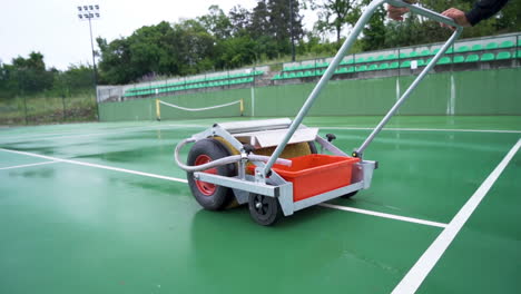 equipo de secado de cancha de tenis en acción en cancha dura