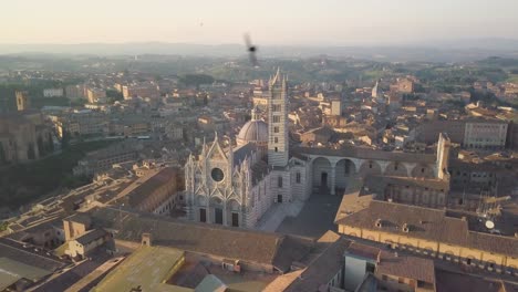 aerial view at sunset of siena medieval town in tuscany italy, drone rotate around main cathedral duomo in gothic style, travel holiday destination