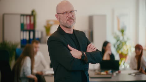 confident manager standing by desk in office.