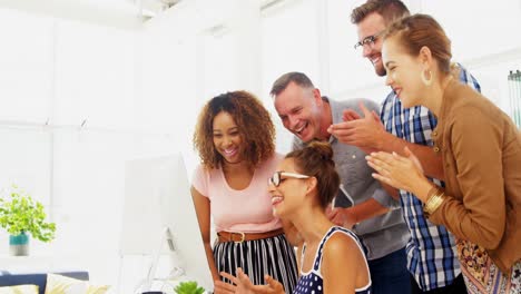 Team-of-executives-discussing-over-computer