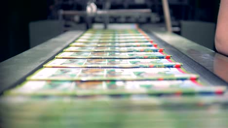 una parte de los diarios que salen de una máquina de fábrica se está recogiendo