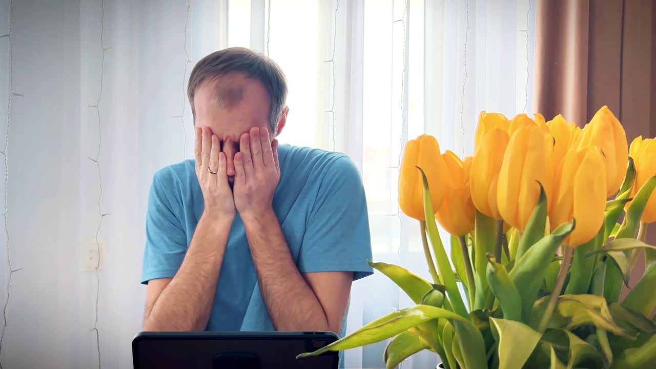 Un uomo concentrato sul lavoro su un tablet in un moderno ambiente di ufficio domestico. Perfetto per illustrare il lavoro a distanza, le soluzioni SaaS, il freelancing e i temi di produttività digitale