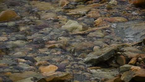 waves crashing on the pebbles and rocks in the lake