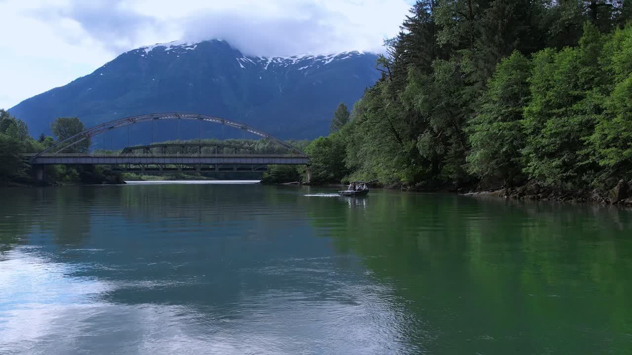 캐나다 북부 브리티시 컬럼비아의 다리 아래에서 강을 건너는 제트 보트