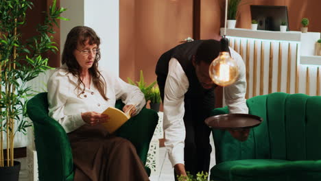 bellboy serving coffee to woman